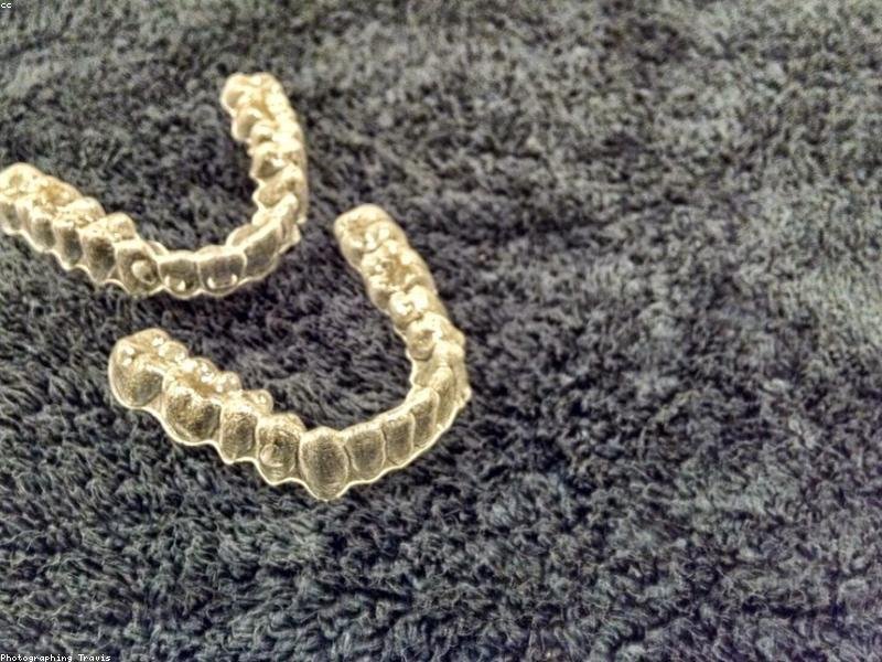 Clear Invisalign aligner tray on a textured surface