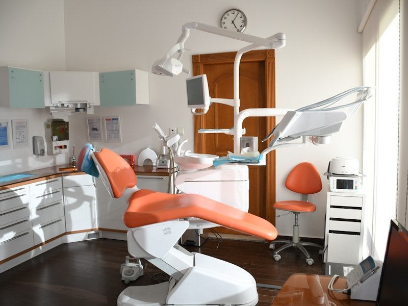 Modern dental operatory with bright orange dental chair and equipment